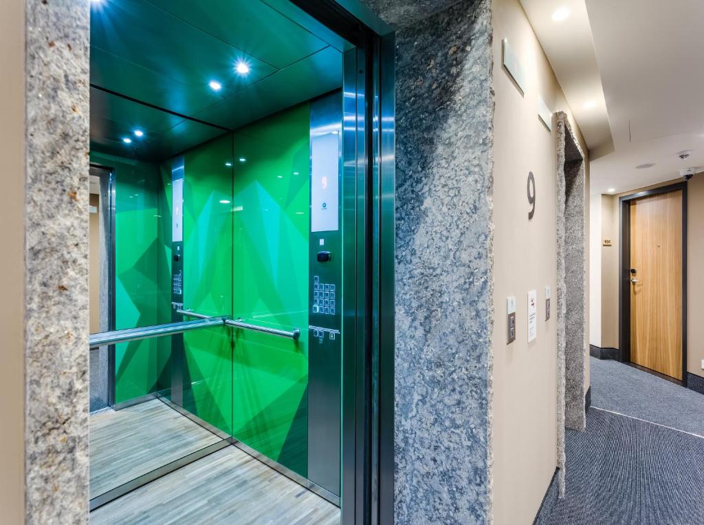 eine Glastür in einem Gebäude mit einer grünen Wand in der Unterkunft Holiday Inn - Warsaw City Centre by IHG in Warschau