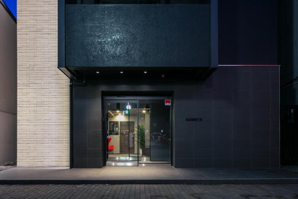 an entrance to a building with a black wall at Randor Residence Susukino Suites in Sapporo