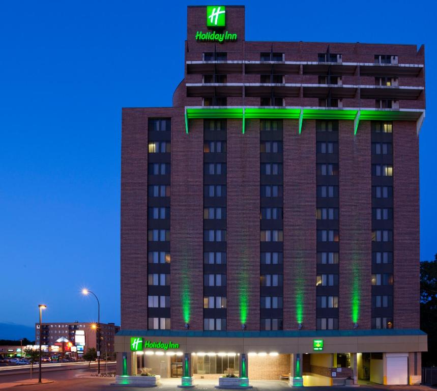 un edificio de hotel con luces verdes en Holiday Inn Winnipeg - Airport West, an IHG Hotel, en Winnipeg