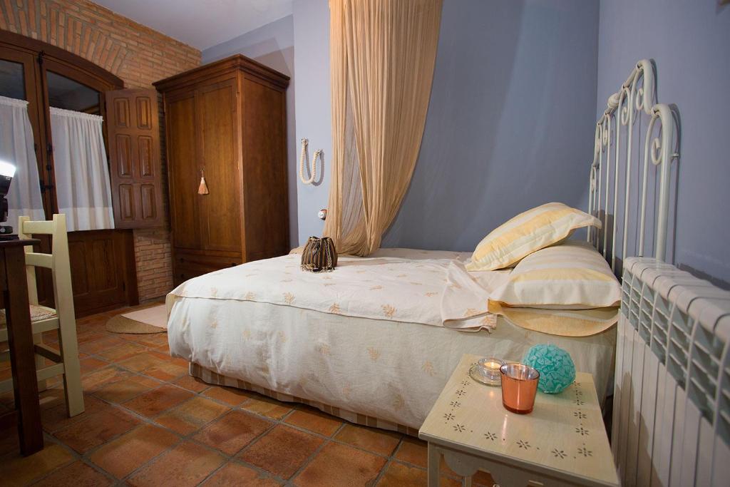 a small bedroom with a bed and a table at Casa Rural El Tenado in Aldea de Trujillo