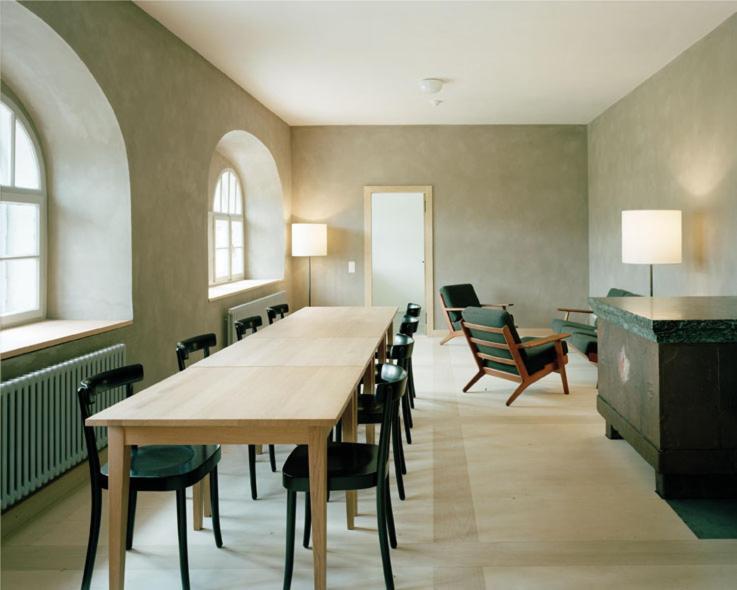 a large room with a long table and chairs at Ospizio San Gottardo in Airolo