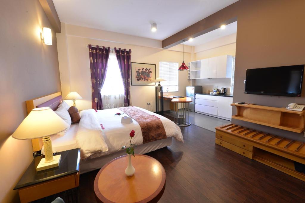 a hotel room with a bed and a television at Hanoi Golden Sunshine Villa Hotel and Travel in Hanoi