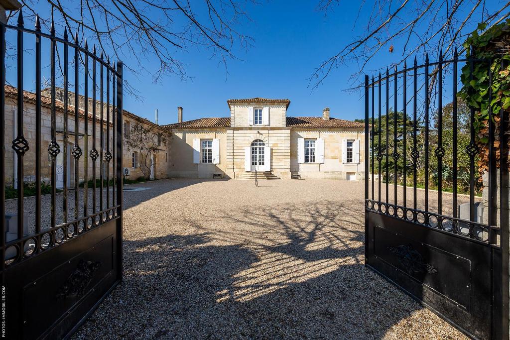 an entrance to a house with a gate in front at Domaine du chauvet in Sainte-Eulalie