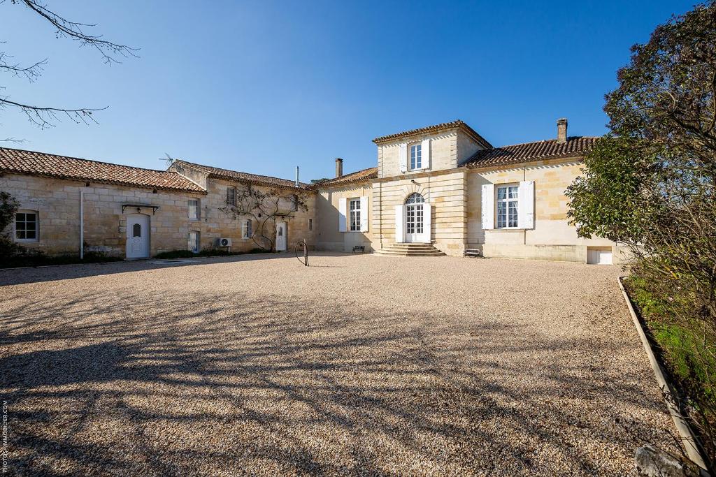 an old stone house with a large driveway at Domaine du chauvet in Sainte-Eulalie