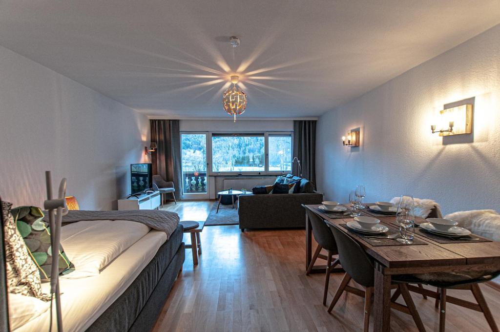 uma sala de estar com uma cama e uma sala de jantar em Steinfeldstudio in Rottach Egern em Rottach-Egern