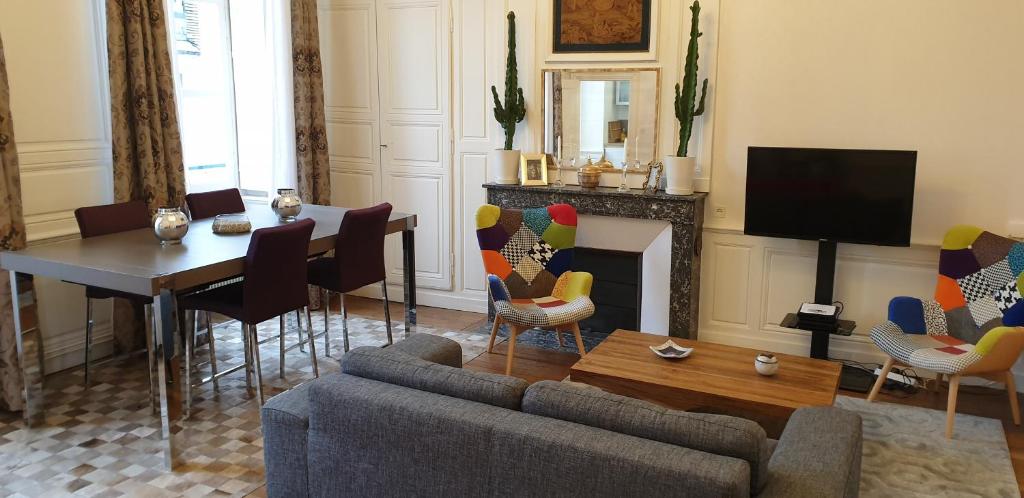 ein Wohnzimmer mit einem Sofa und einem Tisch in der Unterkunft Calme et au cœur du centre historique in Bourges