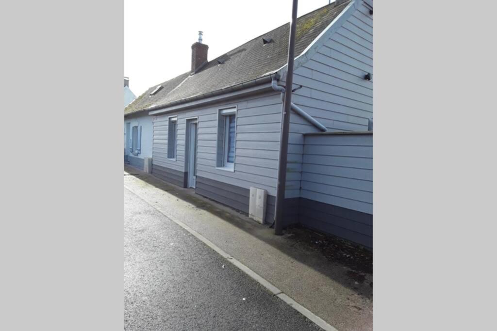 eine Reihe blauer Gebäude neben einer Straße in der Unterkunft LA CIGALIERE à St Valery sur Somme in Saint-Valery-sur-Somme