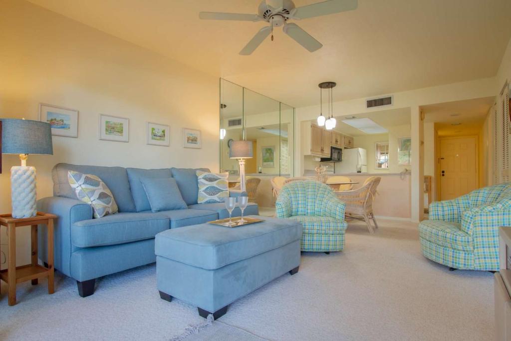 a living room with a blue couch and chairs at Park Shore Resort, 1st Floor, Bldg. B in Naples
