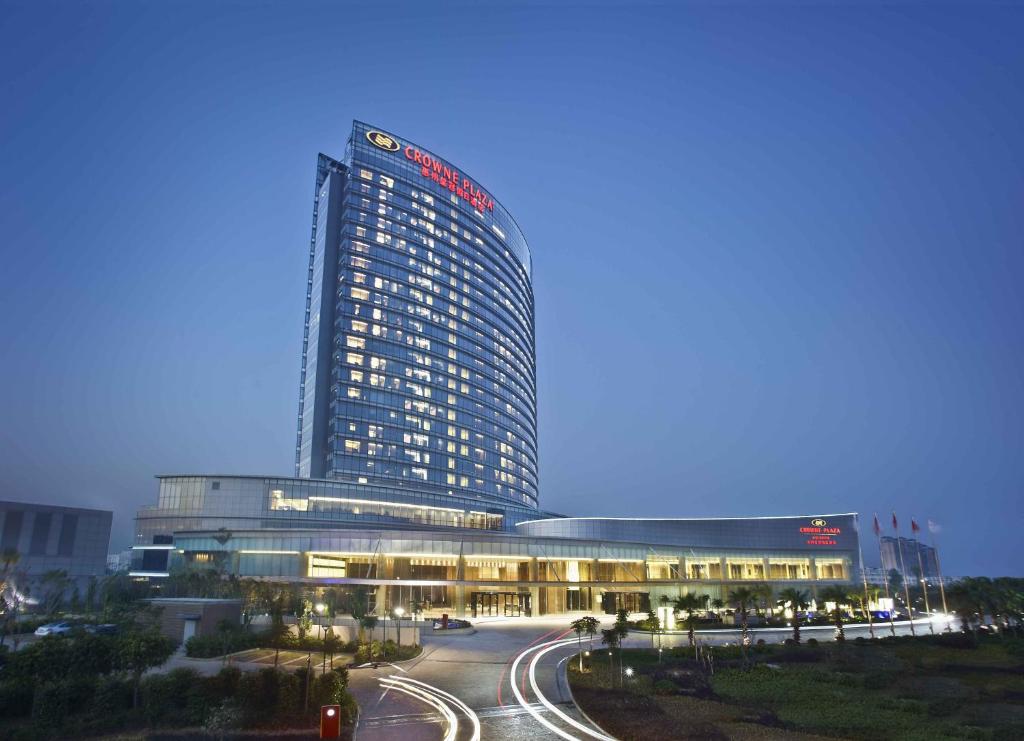 un edificio iluminado con una carretera delante de él en Crowne Plaza Huizhou, an IHG Hotel, en Huizhou