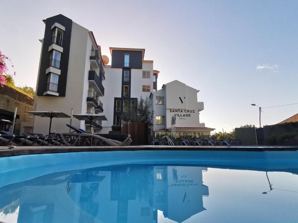 uma piscina em frente a um edifício em Santa Cruz Village Hotel em Santa Cruz - Madeira