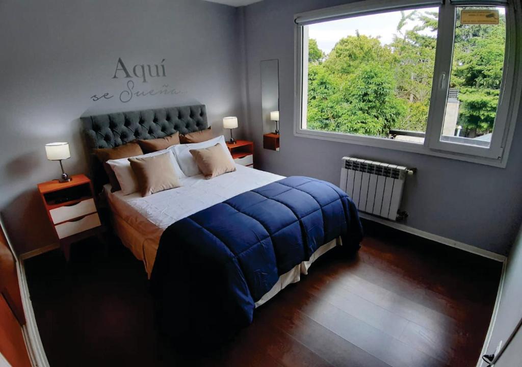 1 dormitorio con 1 cama y ventana grande en Departamento en el centro de Bariloche bb en San Carlos de Bariloche