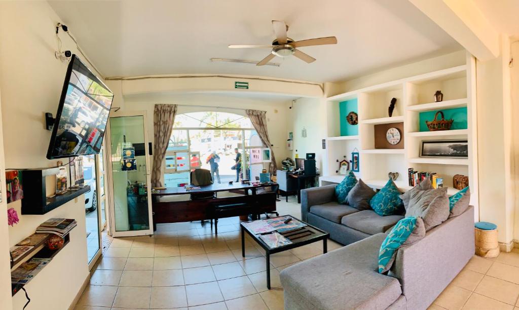 a living room with a couch and a piano at Hostal Bucerias in Bucerías