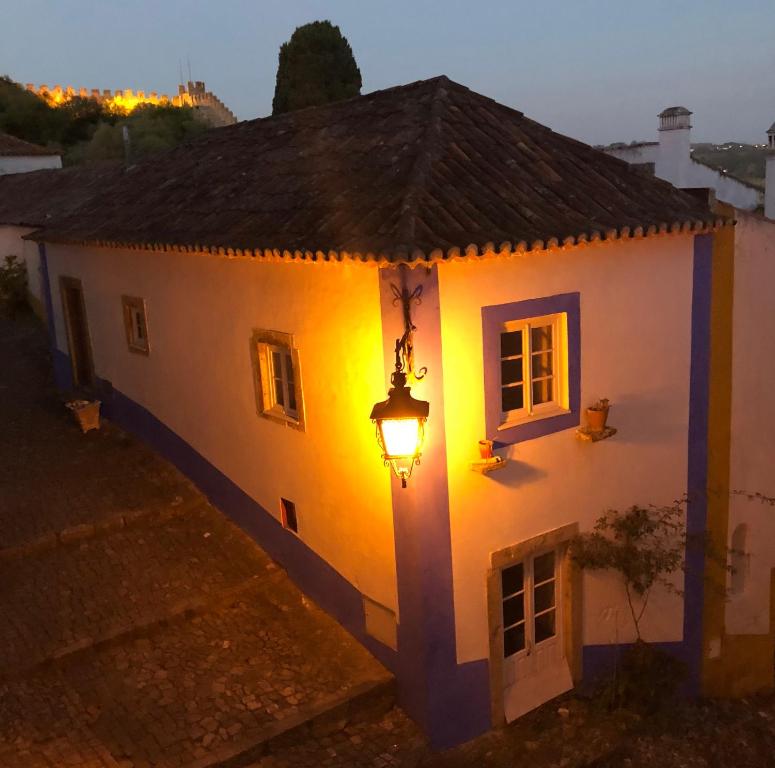 a building with a light on the side of it at The Castle House - Unique Places in Óbidos