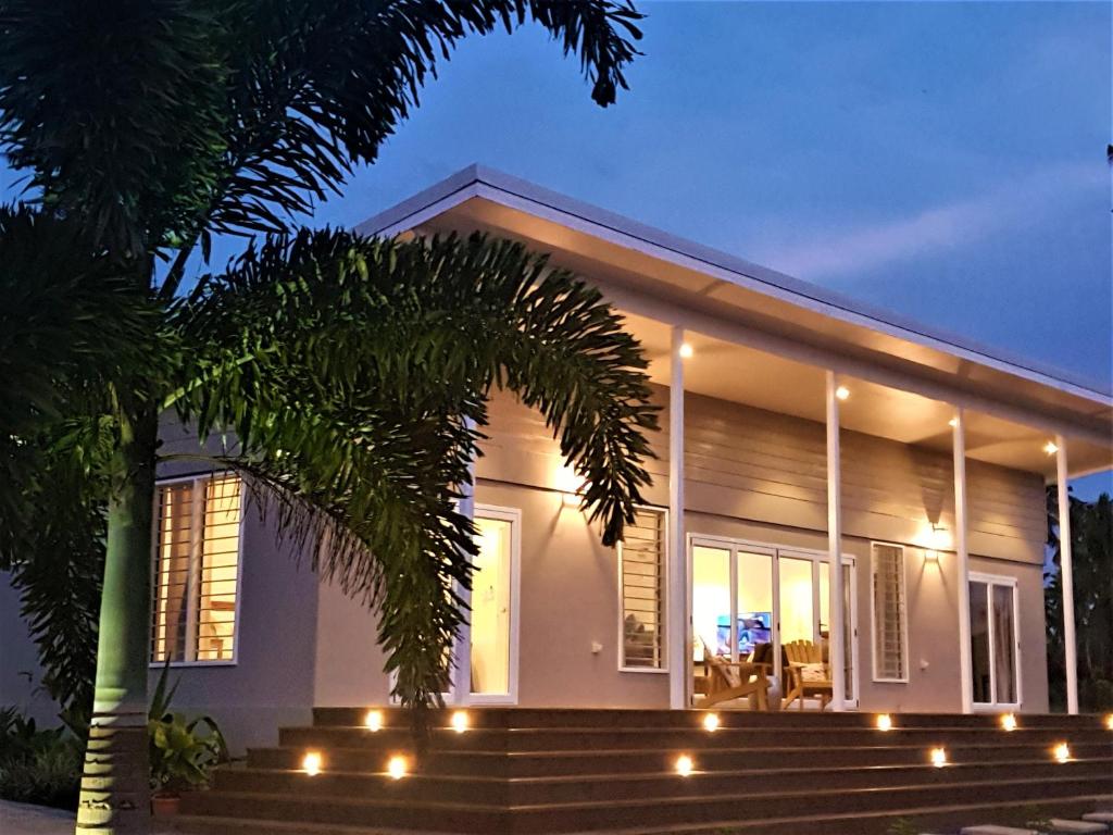 a house with lights on the front of it at Luxury Beachside Home in Maninoa