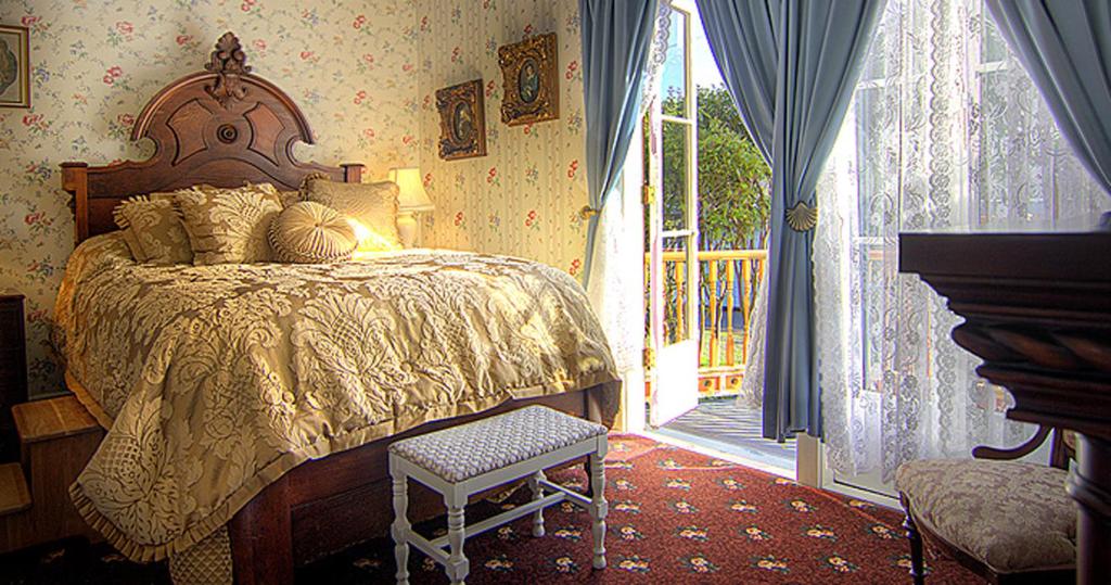 a bedroom with a bed next to a sliding glass door at Gingerbread Mansion in Ferndale