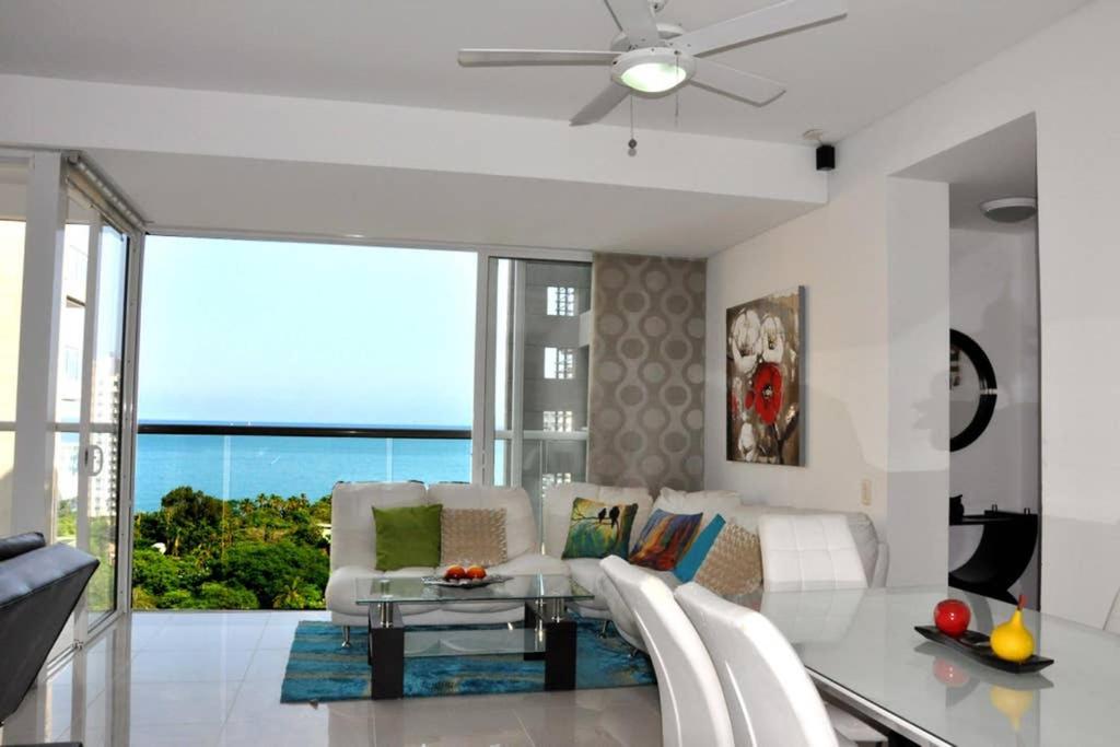 sala de estar con muebles blancos y ventilador de techo en Acogedor con vista al mar en Condominio Zazue a 300 metros de la playa Bellohorizonte Santa Marta, en Santa Marta