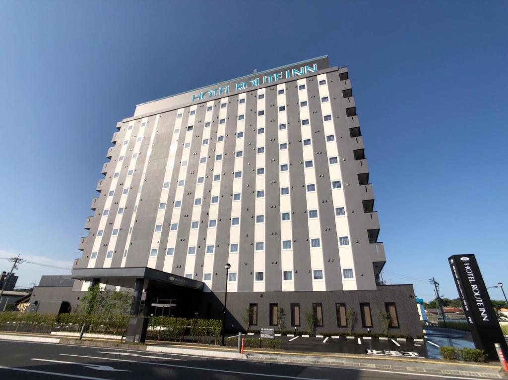 um grande edifício branco com um cartaz em Hotel Route-Inn Masuda em Masuda