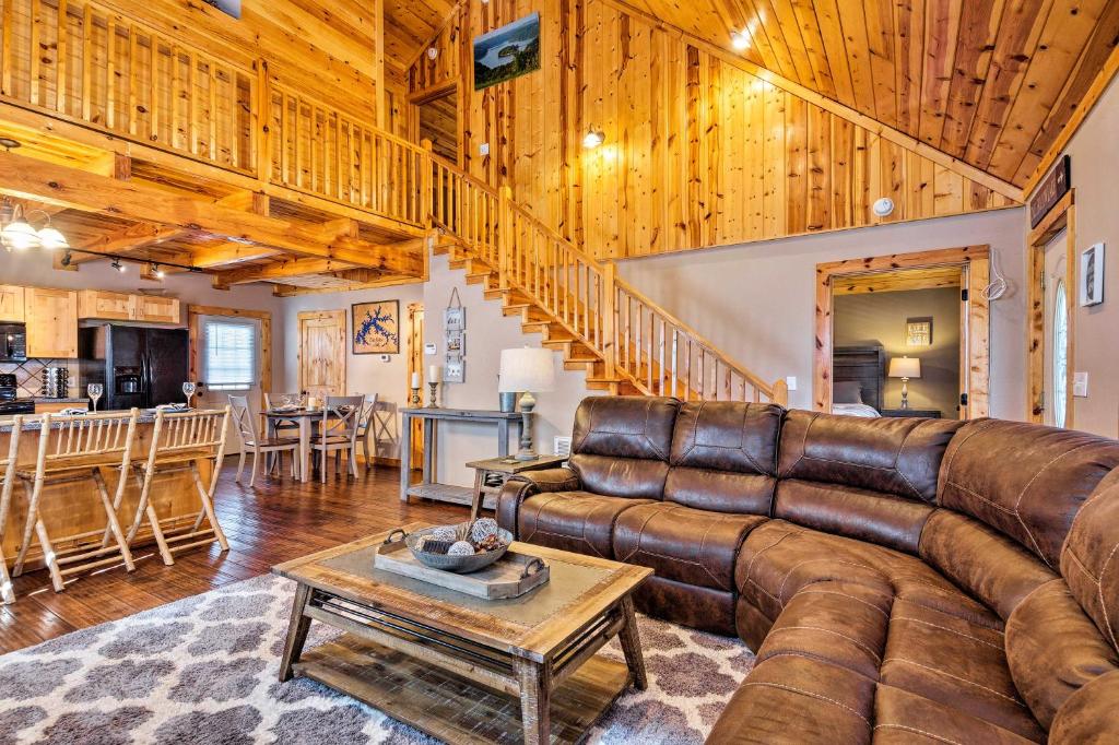 ein Wohnzimmer mit einem Ledersofa und einem Tisch in der Unterkunft Modern Cabin with Grill Near Golf and Bass Fishing! in Frogue