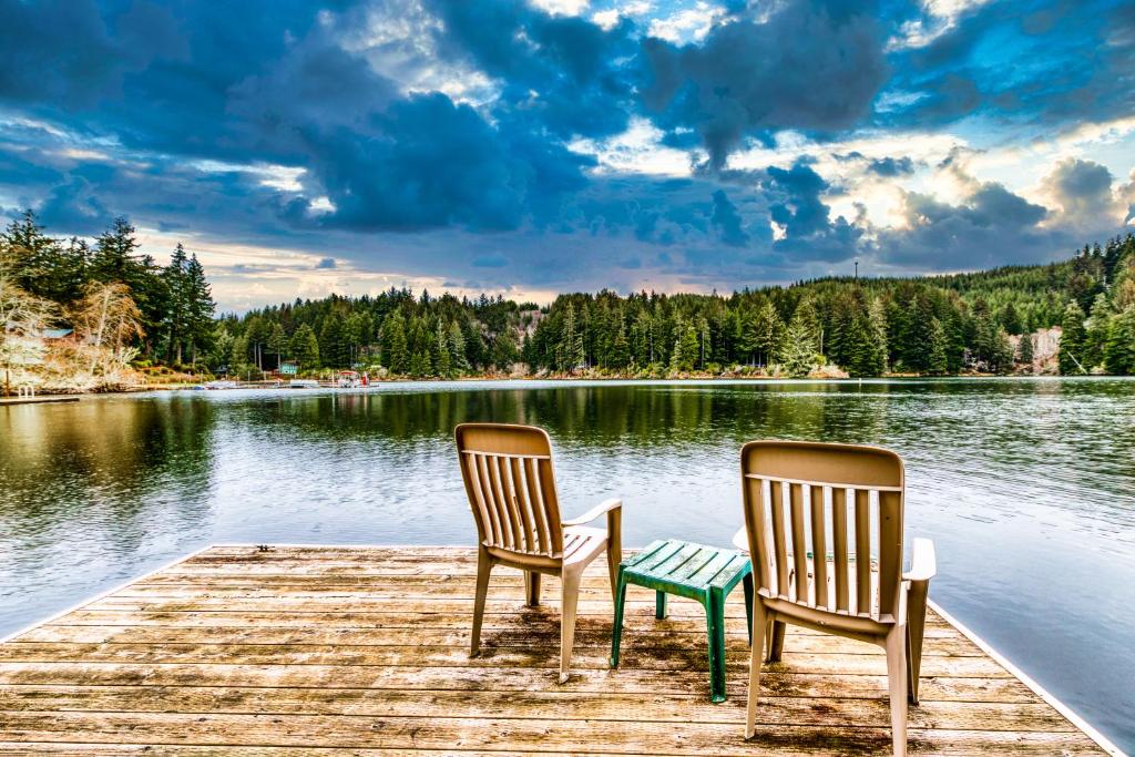 two chairs sitting on a dock on a lake at Marcia's Mercer Lake Chateau in Florence