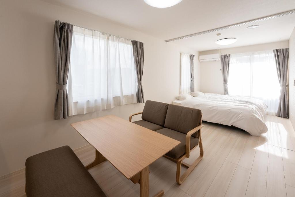 1 dormitorio con cama, mesa de madera y silla en Beans Stay Ishibiki, en Kanazawa