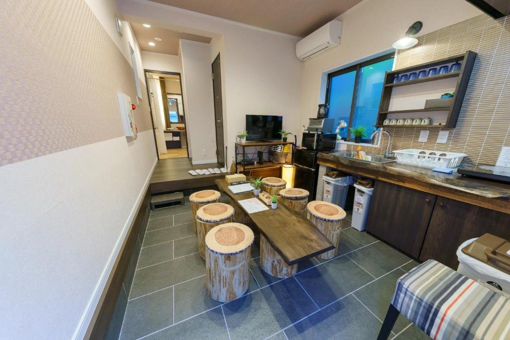 a kitchen with a row of wooden stools at YADOYA Ueno-Rikyu in Tokyo