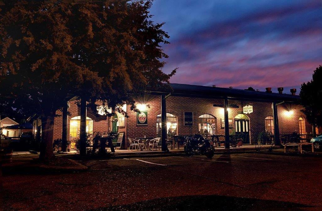 a building with a motorcycle parked in front of it at night at Murrumbateman Country Inn in Murrumbateman