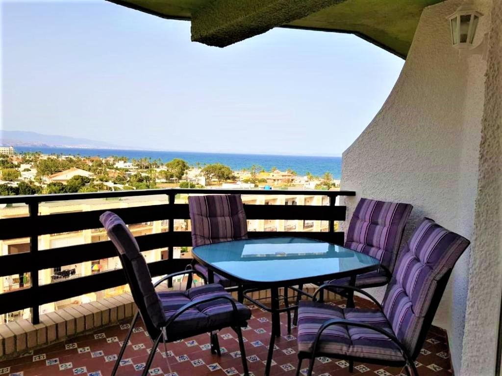 um pátio com uma mesa e cadeiras numa varanda em Apartamento Roquetas de Mar Urbanización, 2 dormitorios, Gran Terraza con vista al mar, wi-fi, parking y piscina em Roquetas de Mar