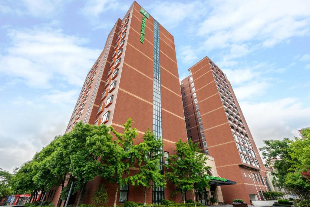 a tall red brick building with a sign on it at Holiday Inn Express Shanghai New Jinqiao, an IHG Hotel in Shanghai