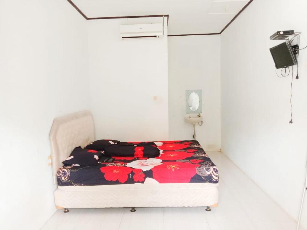 Sawarna的住宿－OYO 3303 Penginapan Putri Asih Sawarna，白色客房的一张床位。
