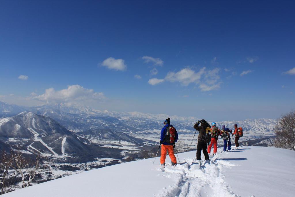 um grupo de pessoas em pé no topo de uma montanha coberta de neve em Aspen Shiga em Yamanouchi