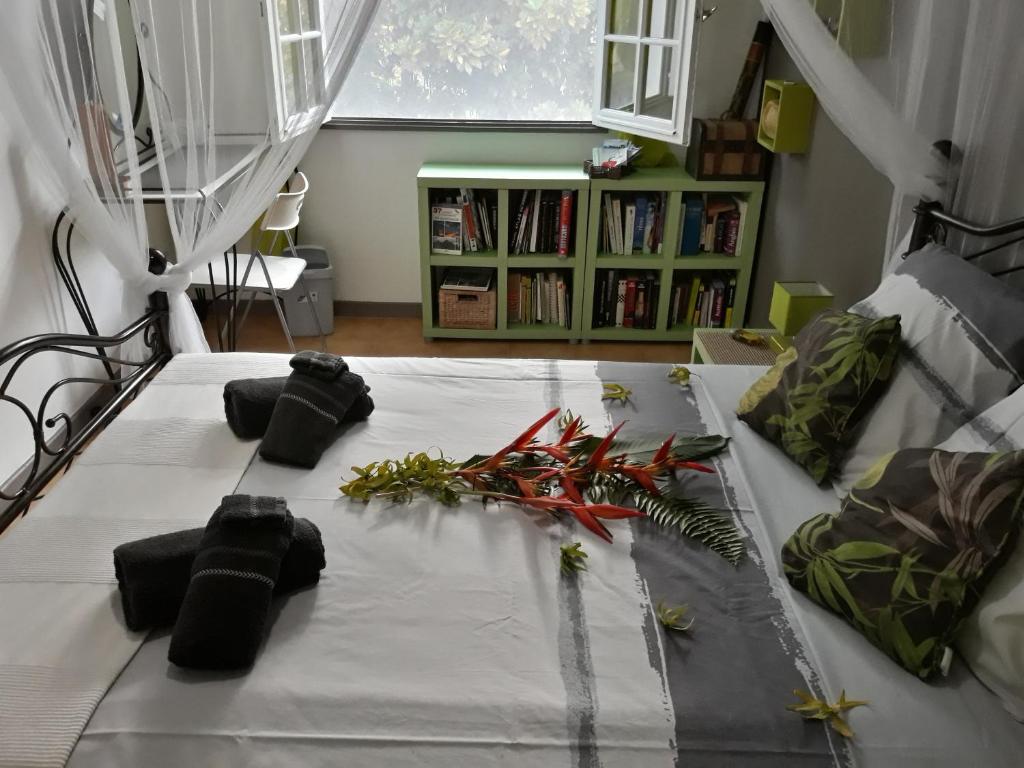 ein weißes Bett mit Blumen in einem Schlafzimmer in der Unterkunft chambre et table d’hôte au Diamant in Le Diamant
