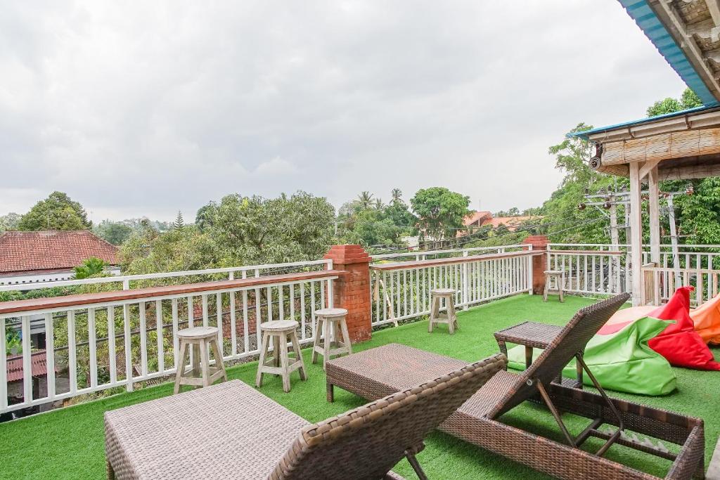 d'une terrasse avec des chaises et des tables sur la pelouse. dans l'établissement Kememai Hostel, à Ubud