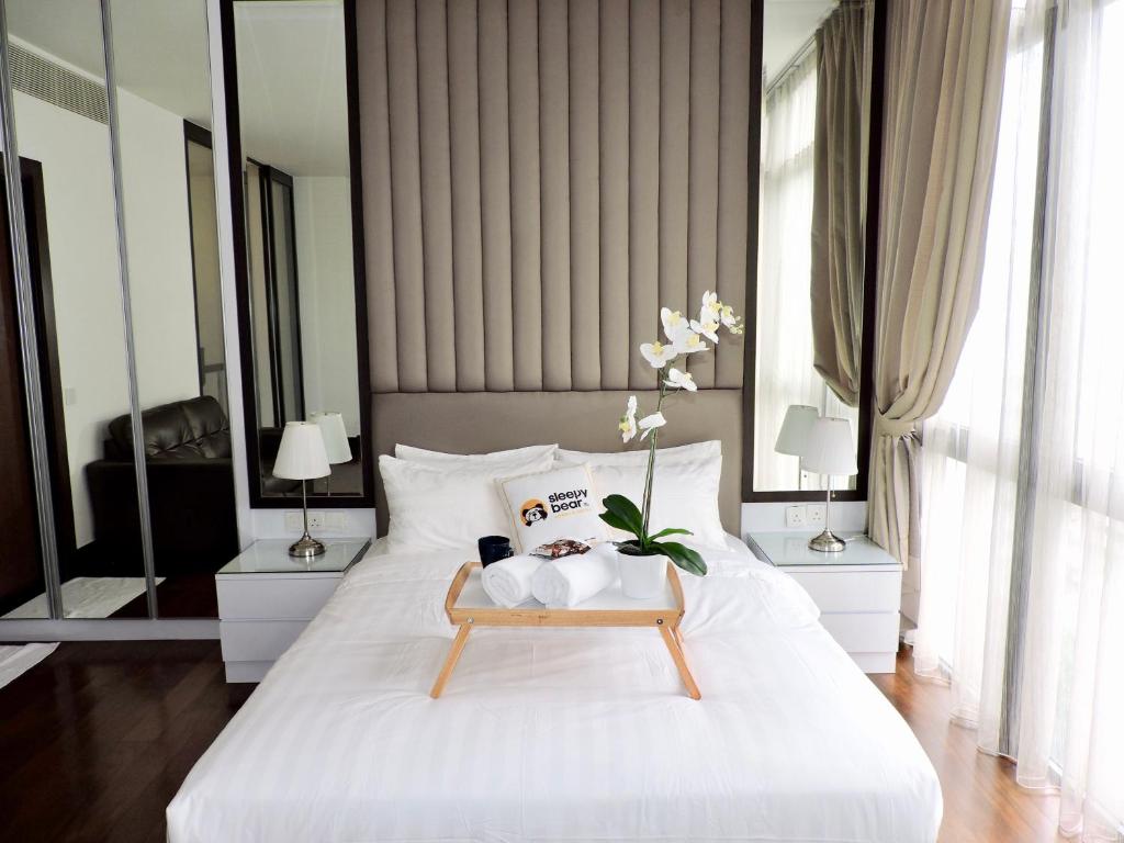 a bedroom with a white bed with a tray on it at Ken Bangsar By Sleepy Bear in Kuala Lumpur