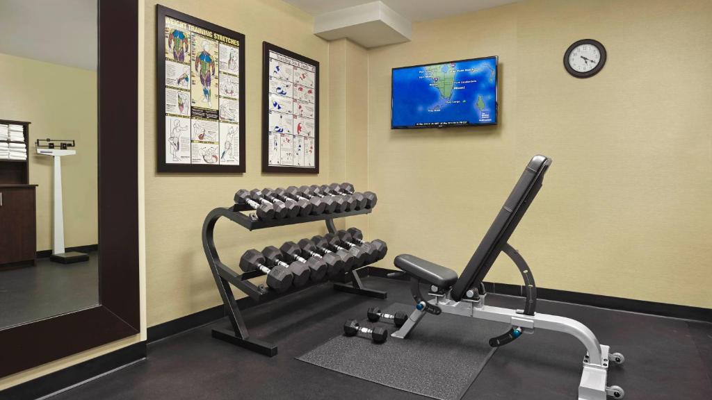 a fitness room with a bench and a clock at Holiday Inn Express & Suites Naples Downtown - 5th Avenue by IHG in Naples