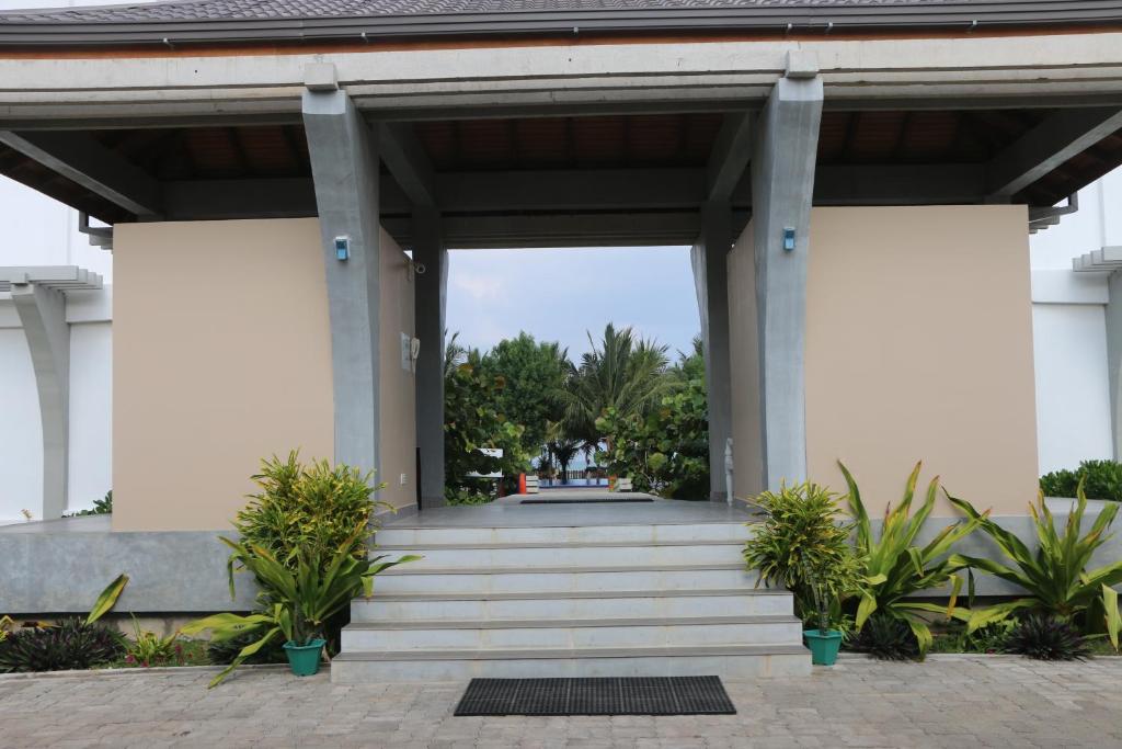 a large white building with stairs and plants at BEACH HAVEN NILAVELI in Nilaveli