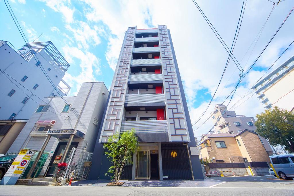 a tall apartment building with a staircase on it at Hotel Amaterrace Yosuga in Osaka