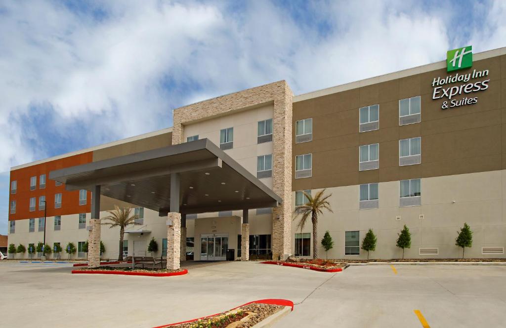 un hotel con aparcamiento frente a un edificio en Holiday Inn Express & Suites - Lake Charles South Casino Area, an IHG Hotel en Lake Charles