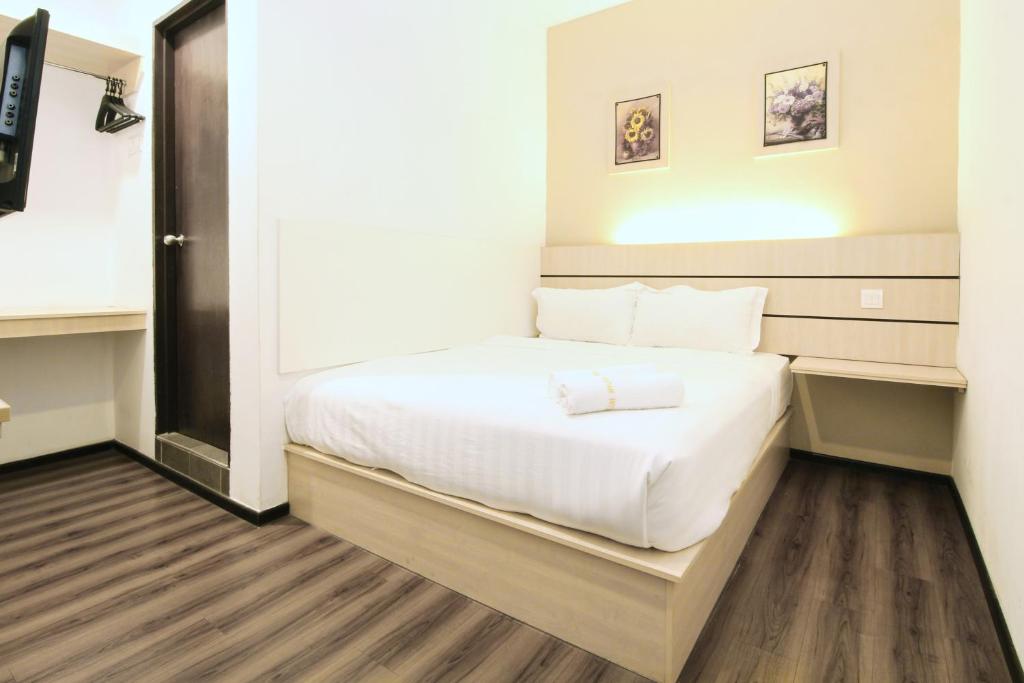 ein Schlafzimmer mit einem weißen Bett in einem Zimmer in der Unterkunft Grand Kapar Hotel Klang Sentral in Klang