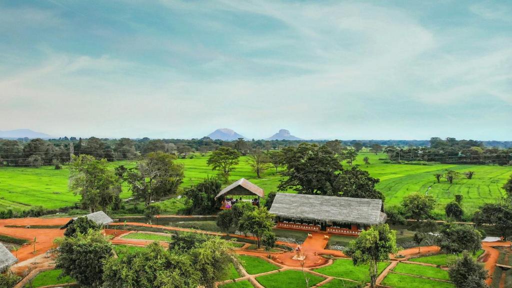 an aerial view of a farm with mountains in the background at Ayurvie Sigiriya - Ayurvedic Retreat by Thema Collection in Sigiriya
