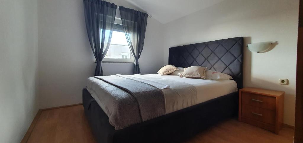 a bedroom with a large bed with a window at Apartments Kolak in Rogoznica