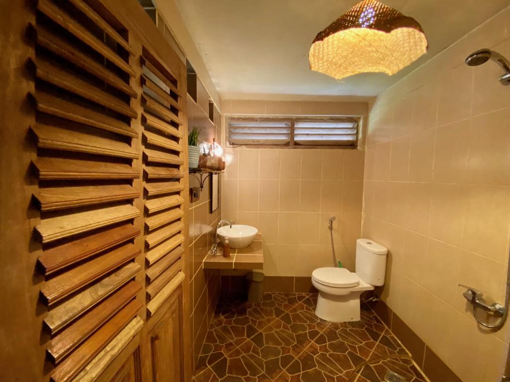 a bathroom with a toilet and a sink at Rinjani Lighthouse in Senaru