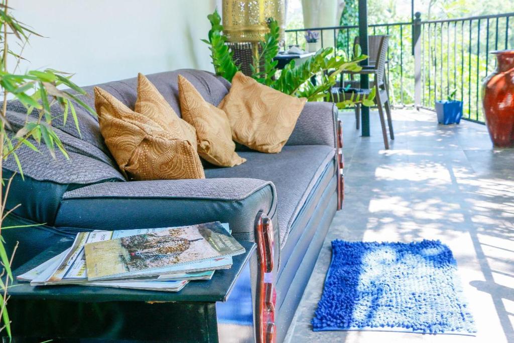 a couch with pillows on a porch with a table at City Breeze Residence in Kandy