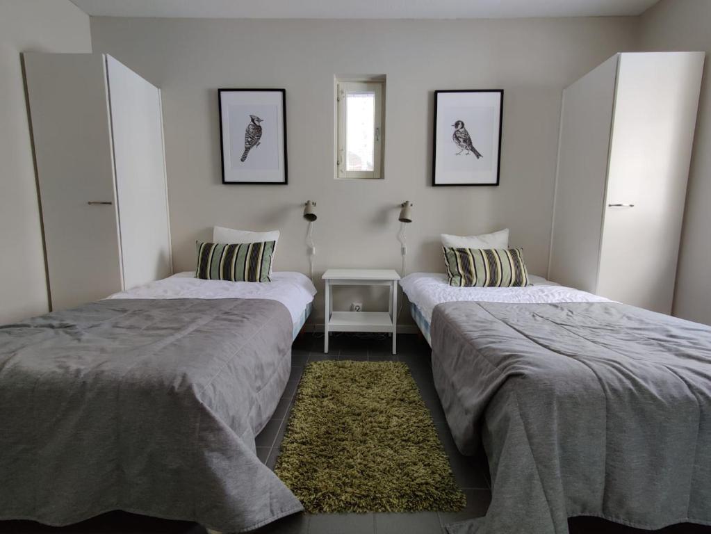 a room with two beds and a table in it at Rauhalahti Holiday Homes in Kuopio