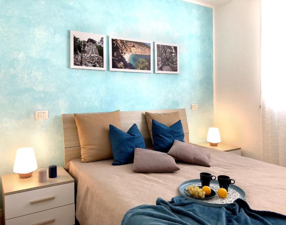 Un dormitorio con una cama con una bandeja de fruta. en Casa Olivastro Vista Mare en Santa Maria Navarrese