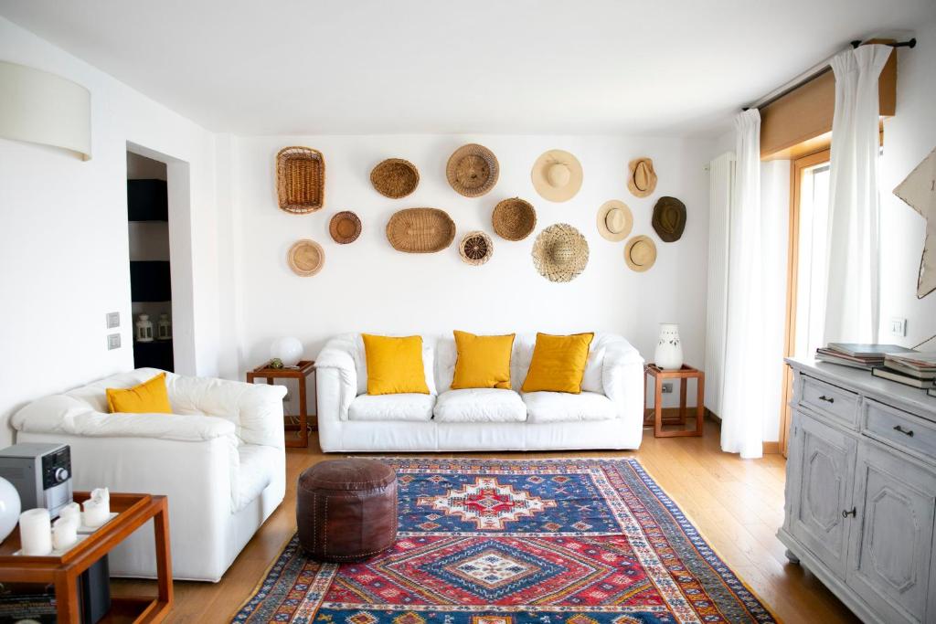 un soggiorno con divano bianco e cuscini gialli di IseoLakeRental - Casa Stella d'Acqua a Sulzano