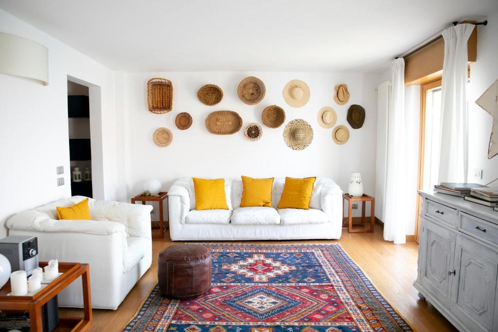 a living room with a white couch and yellow pillows at IseoLakeRental - Casa Stella d'Acqua in Sulzano