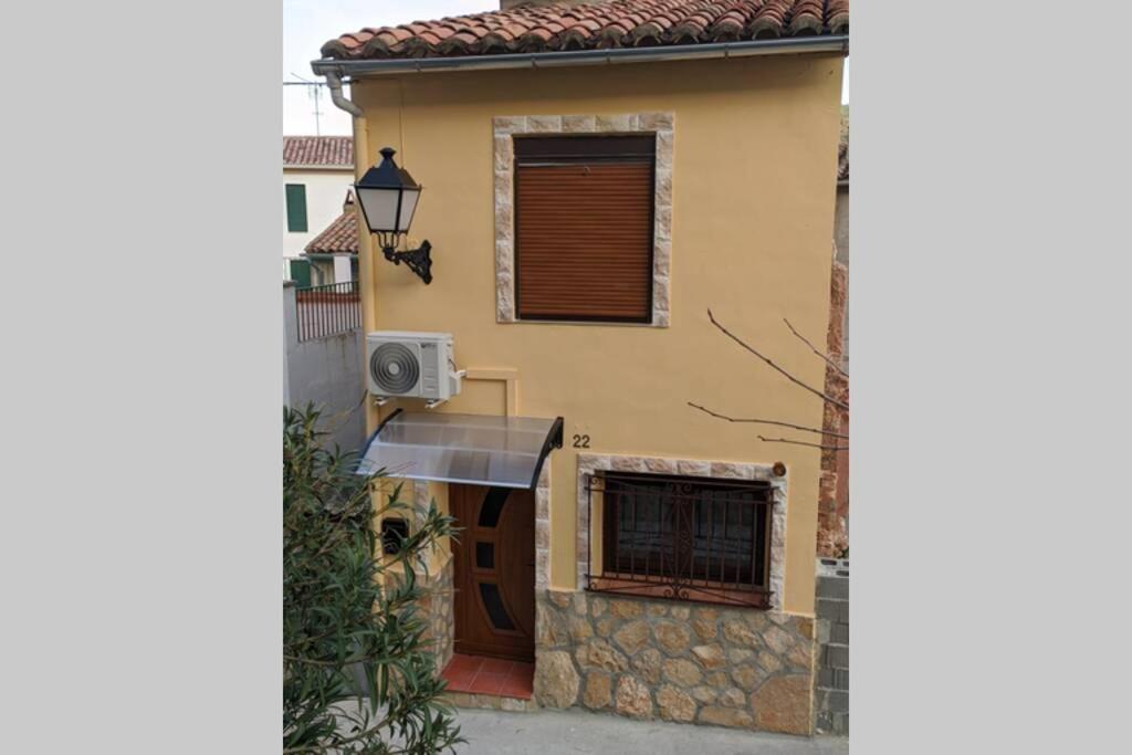 uma casa amarela com uma porta e uma janela em Casa Rural Adriana, Montanejos em Montanejos