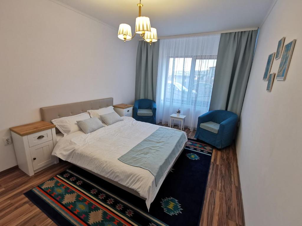 um quarto com uma cama grande e uma cadeira azul em Charming apartment in villa em Iaşi