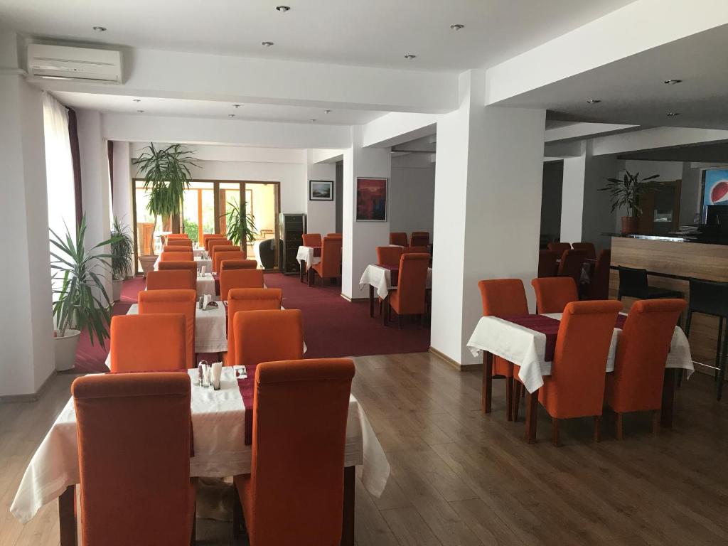 a row of tables and chairs in a restaurant at Old Pensiunea Otopeni in Otopeni