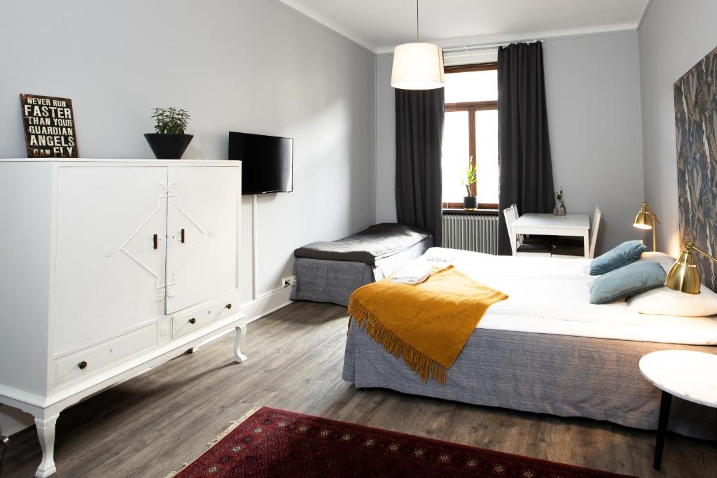 1 dormitorio con 1 cama y 1 silla en Systrar & Bönor Bed and Breakfast, en Trelleborg